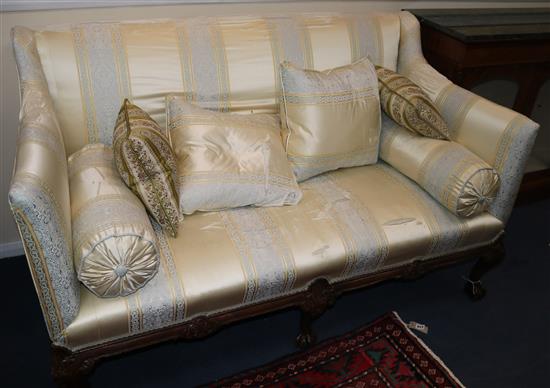 A Georgian style carved mahogany settee, covered in silk, on cabriole legs, W.150cm